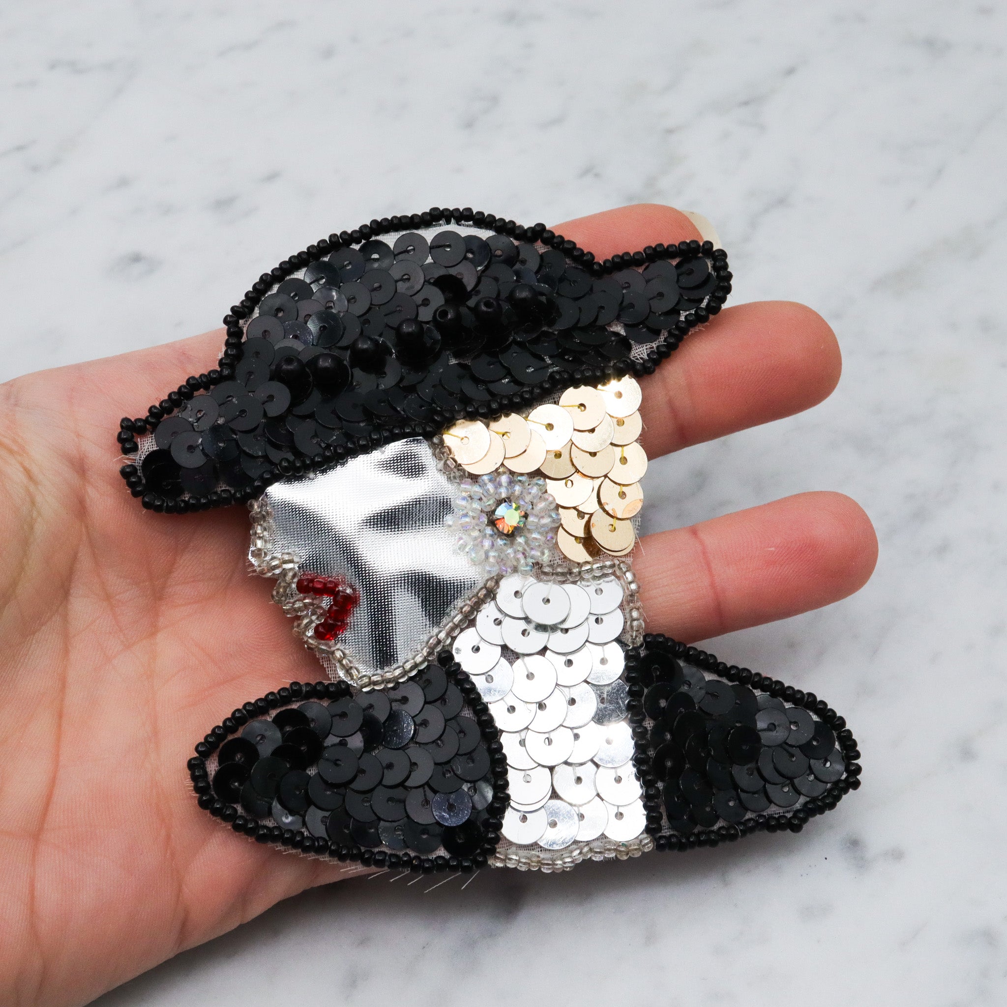 1980's handmade sequin applique brooch of a woman in a black hat