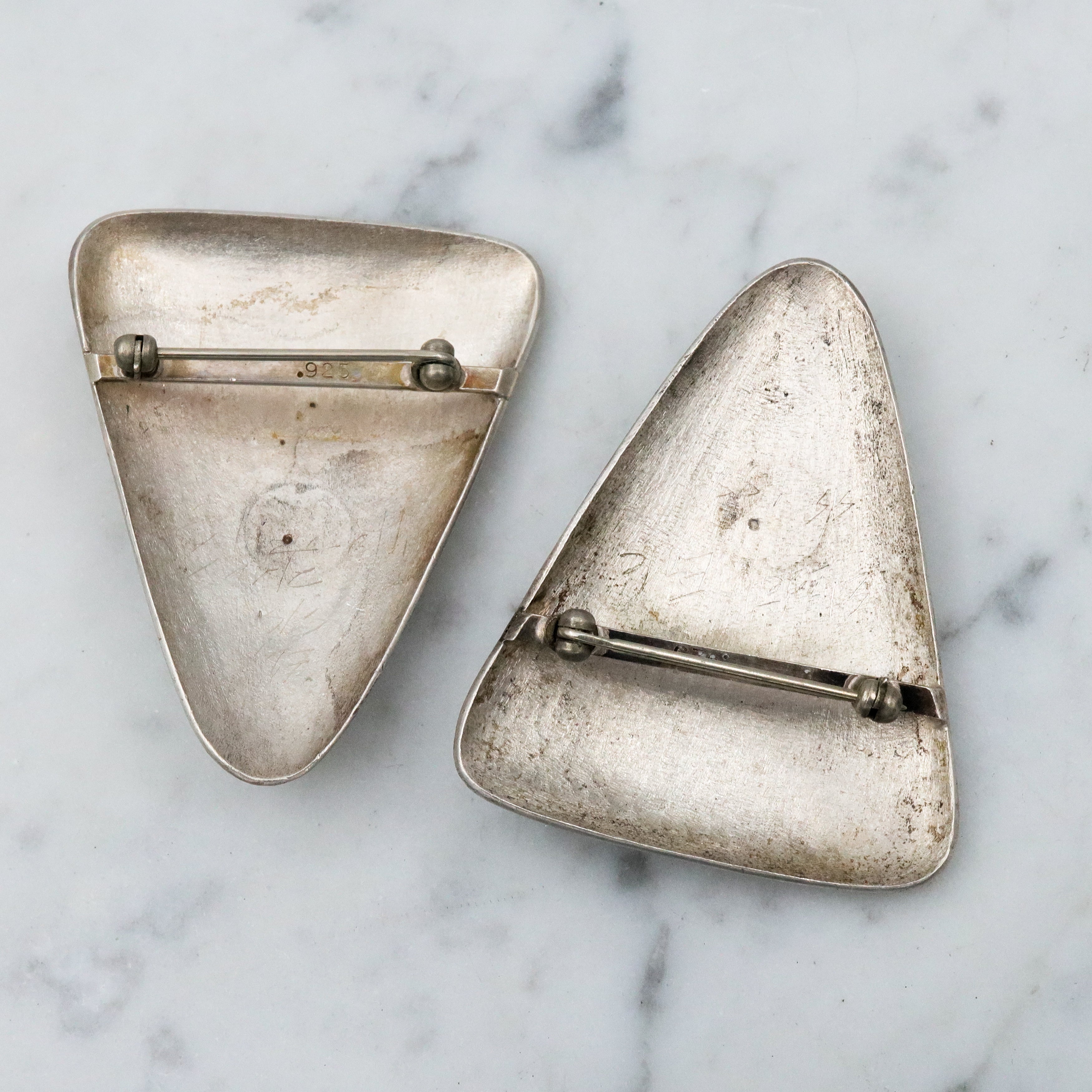 1987 pair of brushed sterling mask brooches by Modernist artist Elizabeth Earle