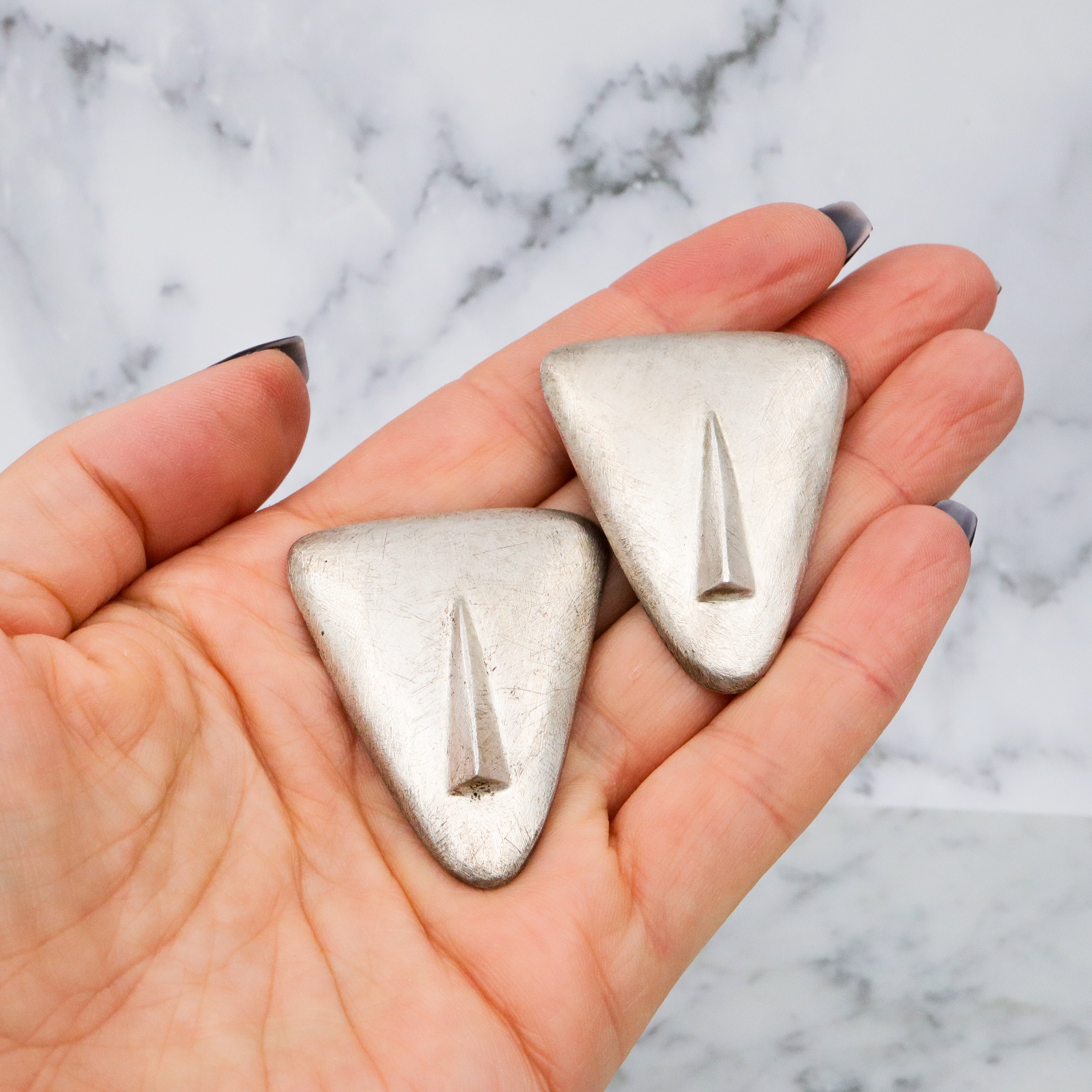 1987 pair of brushed sterling mask brooches by Modernist artist Elizabeth Earle