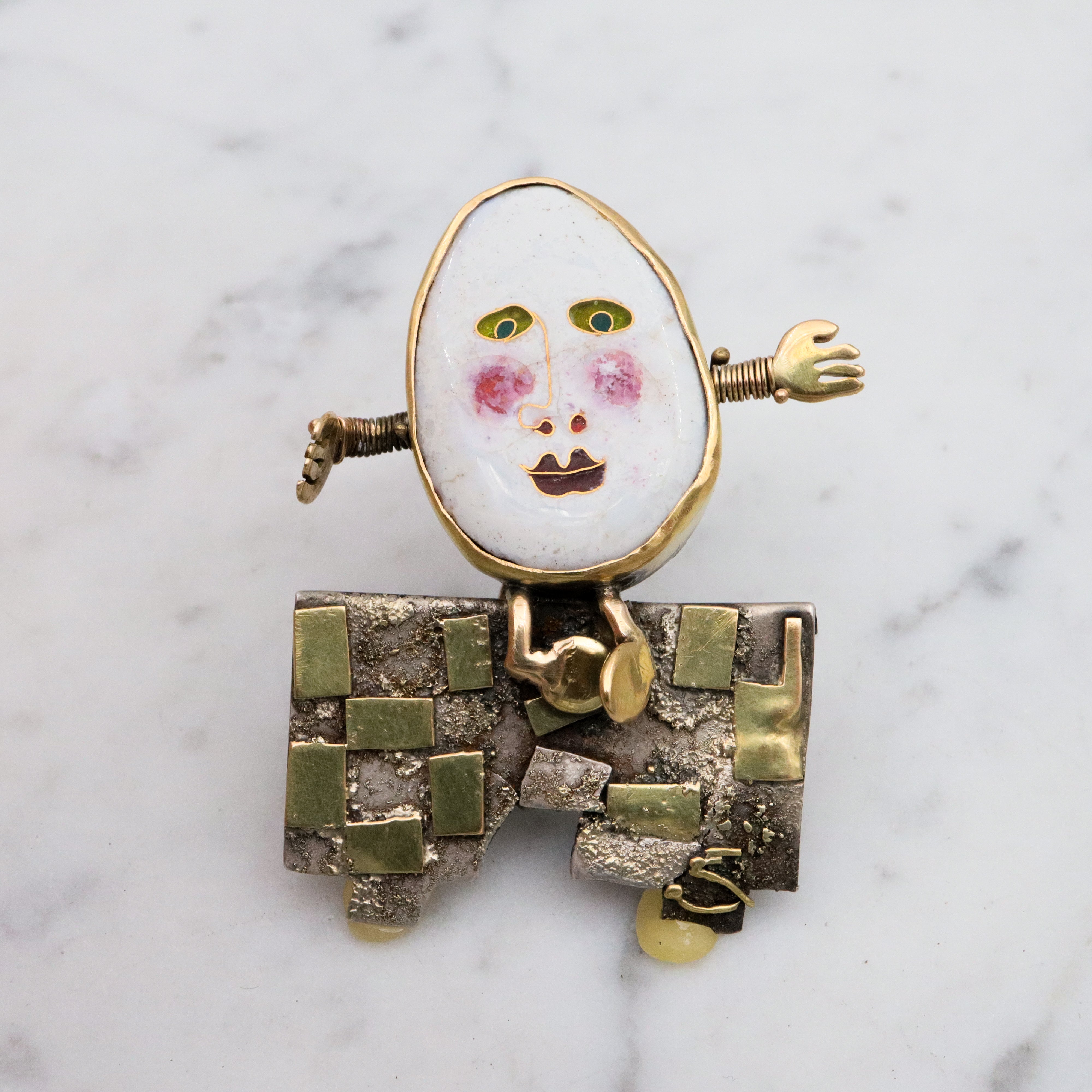 Incredible Avant-garde gold plated sterling & ceramic egg face sitting on wall brooch