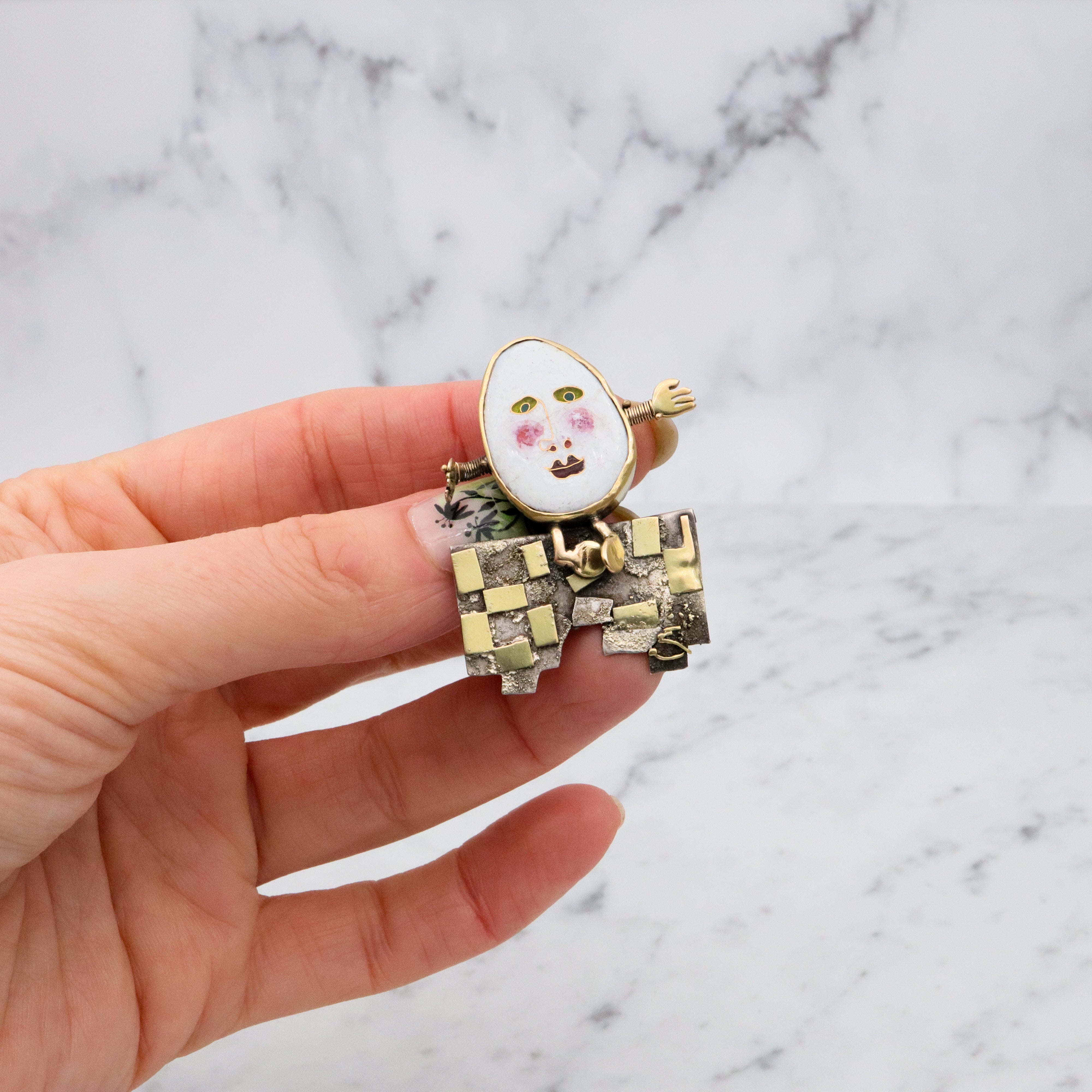 Incredible Avant-garde gold plated sterling & ceramic egg face sitting on wall brooch