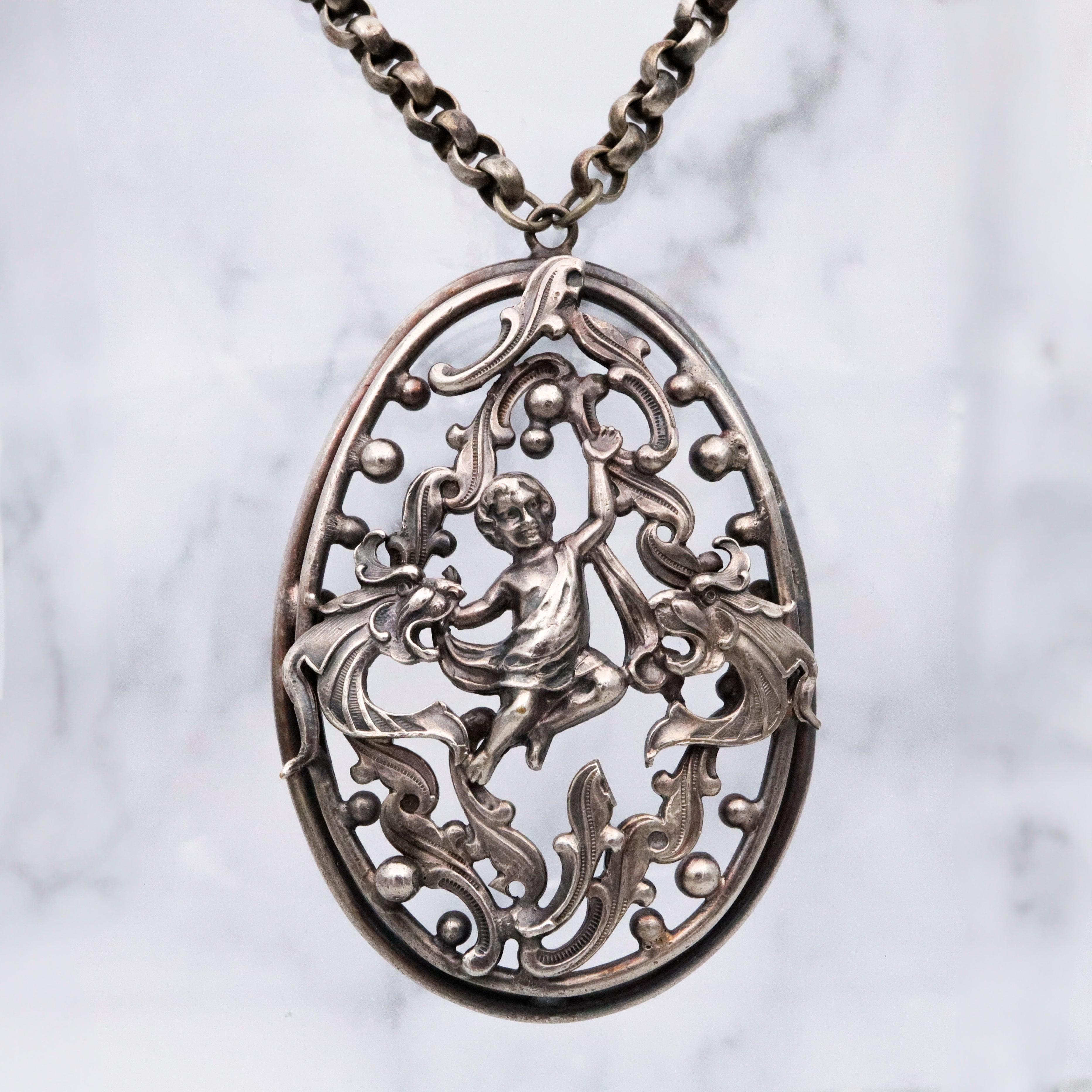 Antique Renaissance Revival silver plated putti & dragon cutout pendant necklace