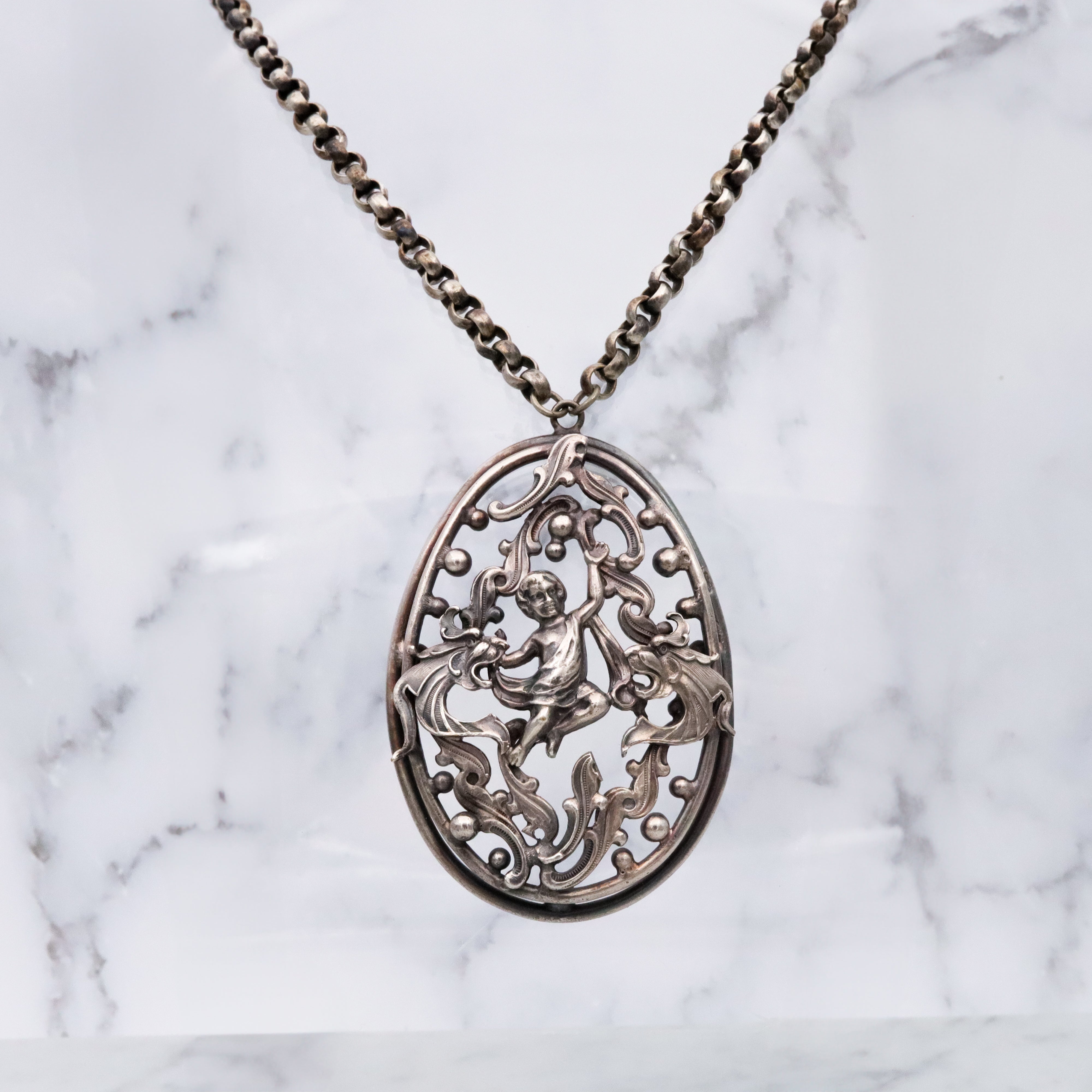 Antique Renaissance Revival silver plated putti & dragon cutout pendant necklace