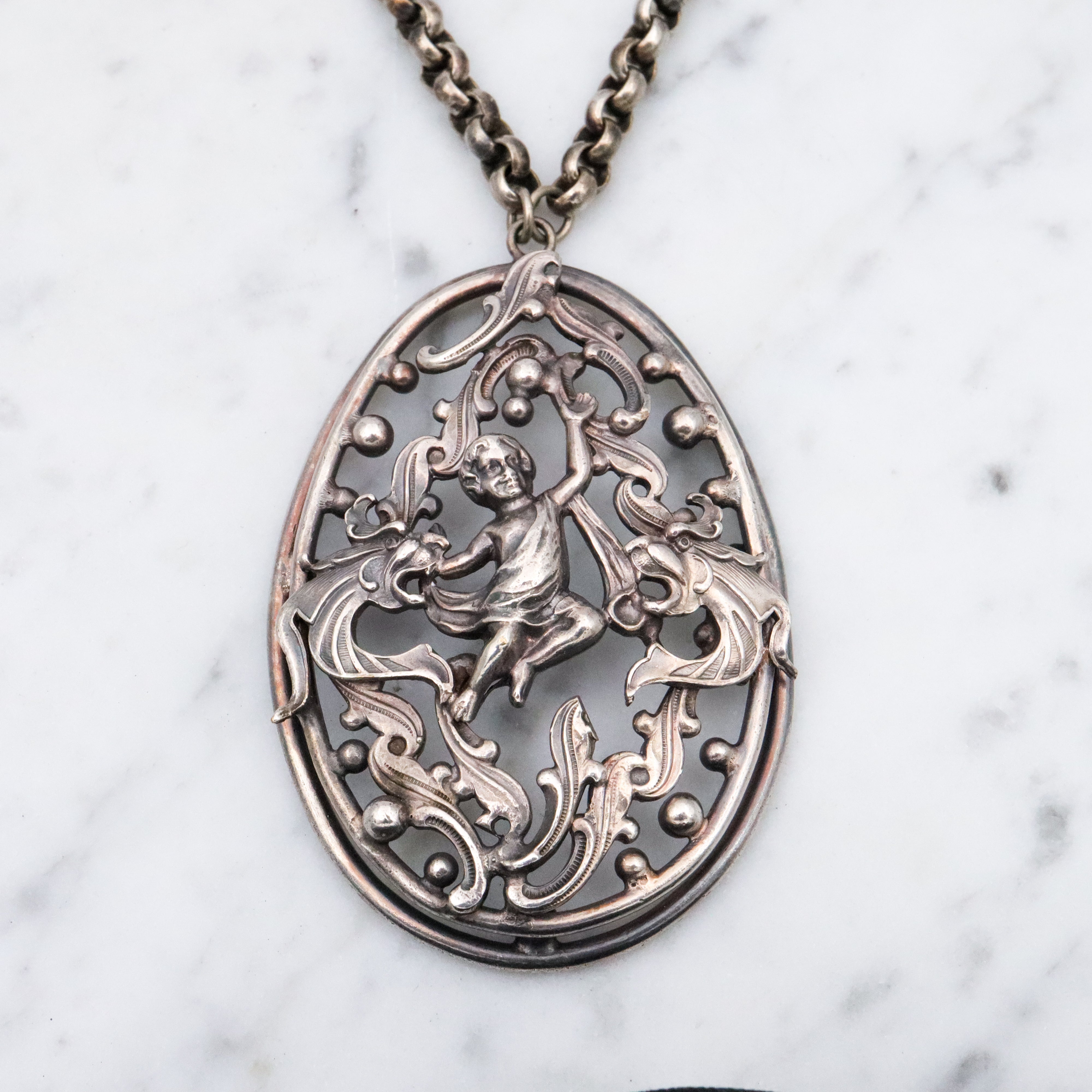 Antique Renaissance Revival silver plated putti & dragon cutout pendant necklace