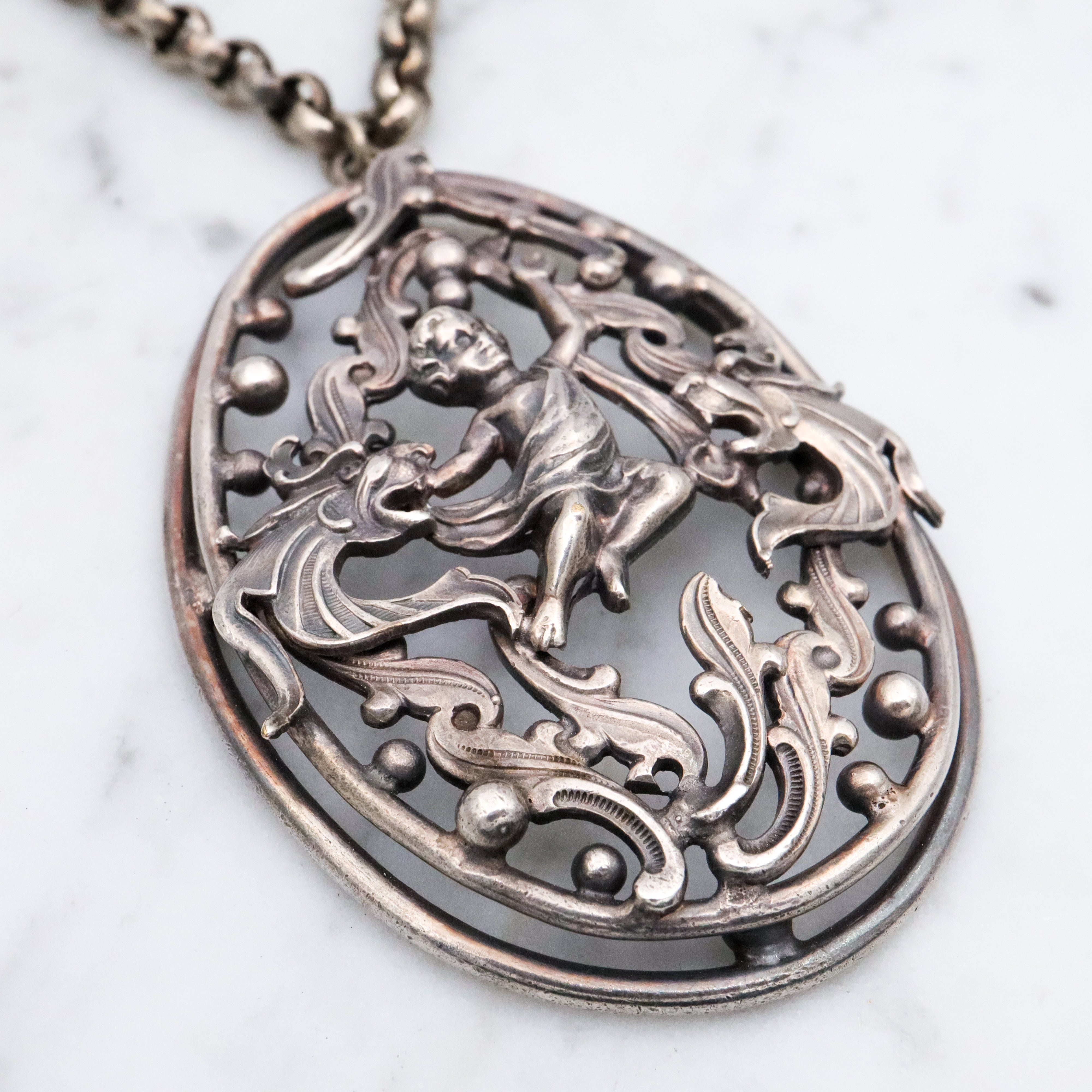 Antique Renaissance Revival silver plated putti & dragon cutout pendant necklace