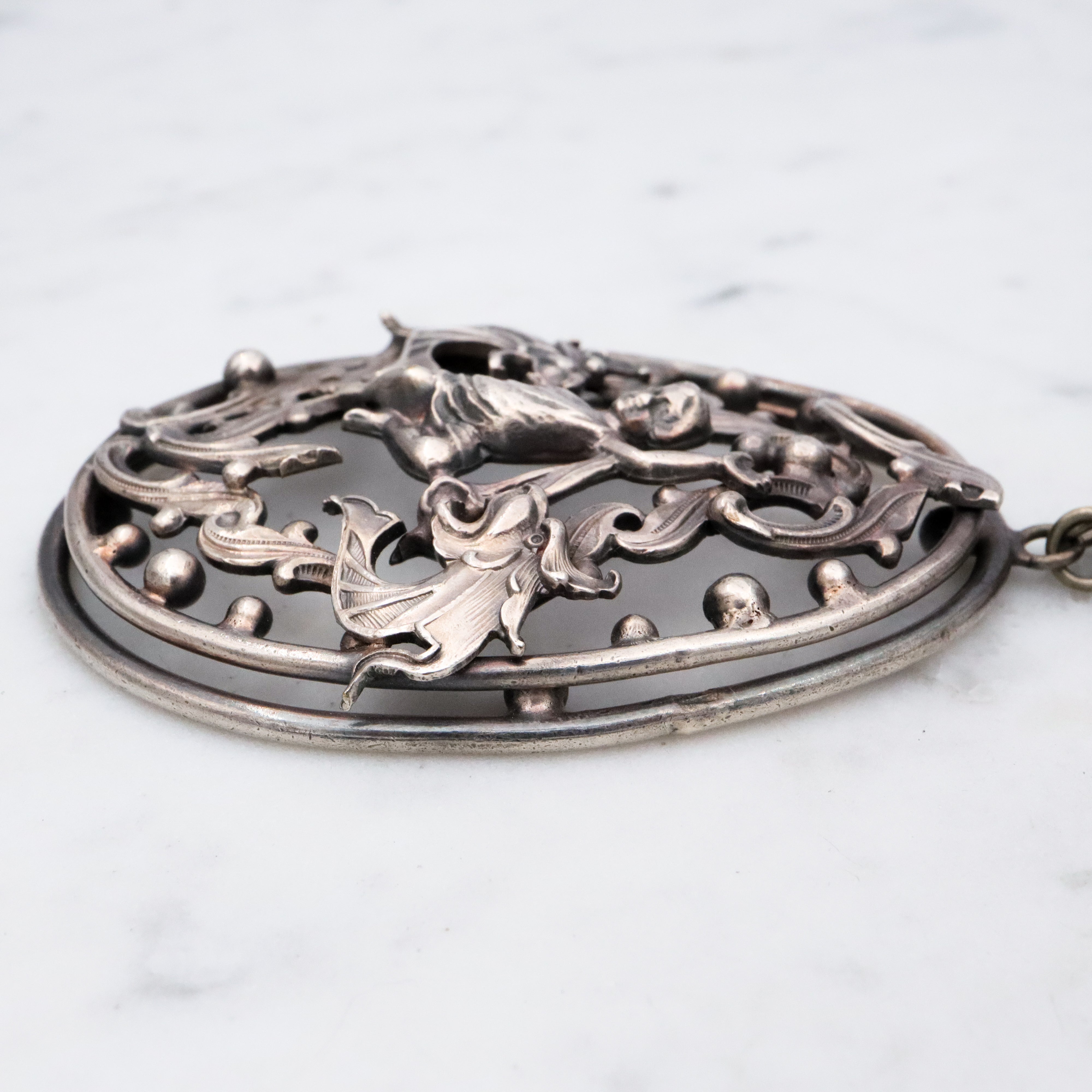 Antique Renaissance Revival silver plated putti & dragon cutout pendant necklace