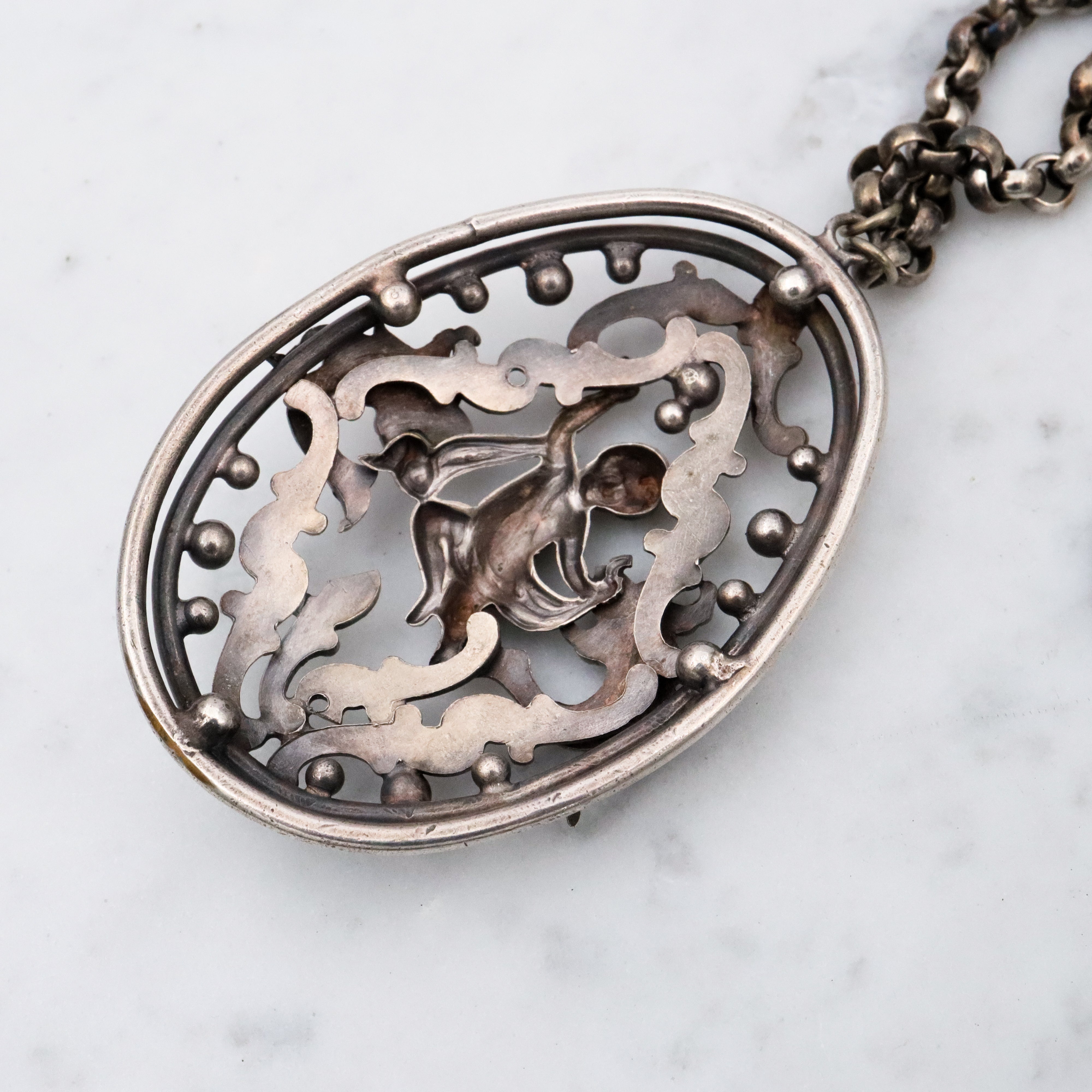 Antique Renaissance Revival silver plated putti & dragon cutout pendant necklace