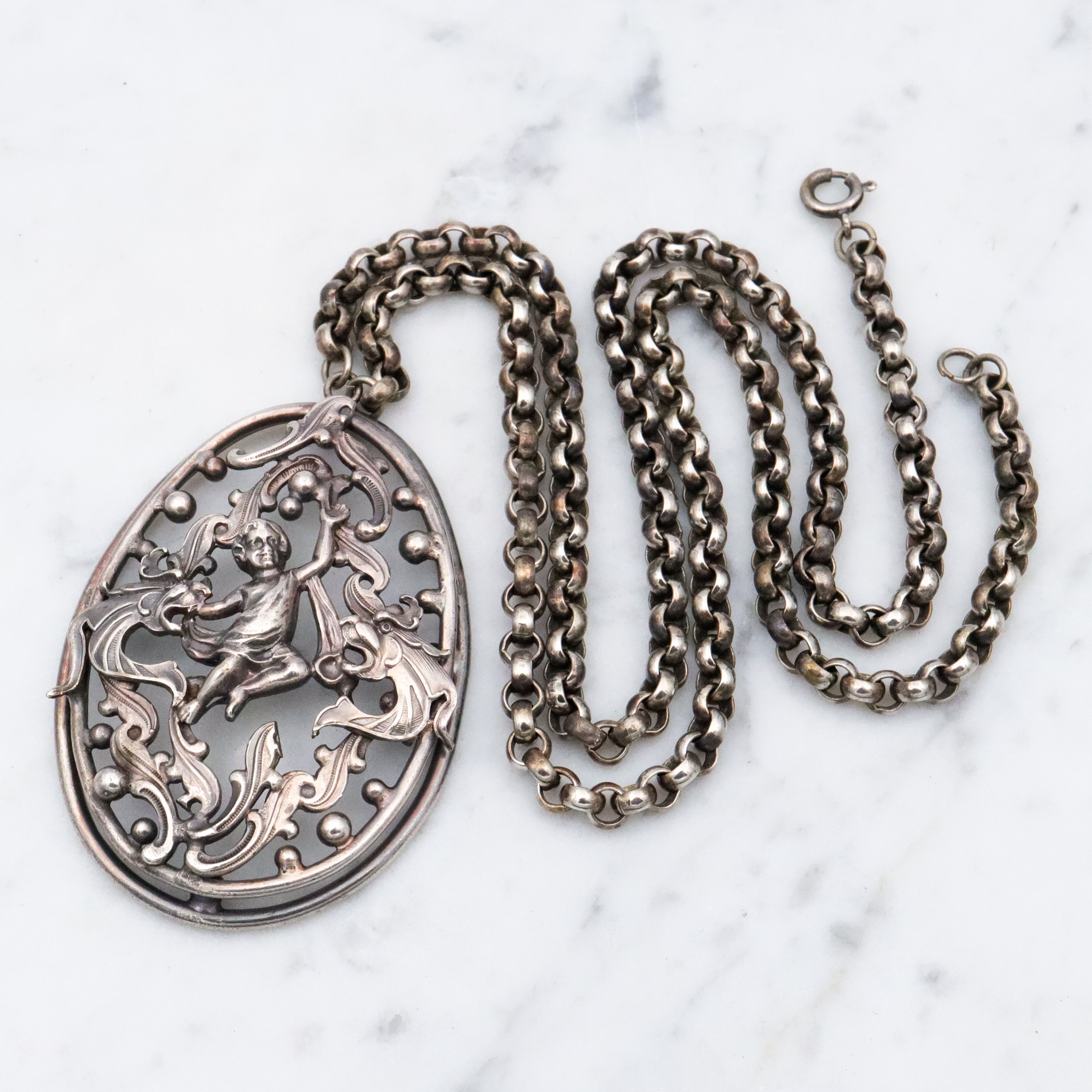 Antique Renaissance Revival silver plated putti & dragon cutout pendant necklace