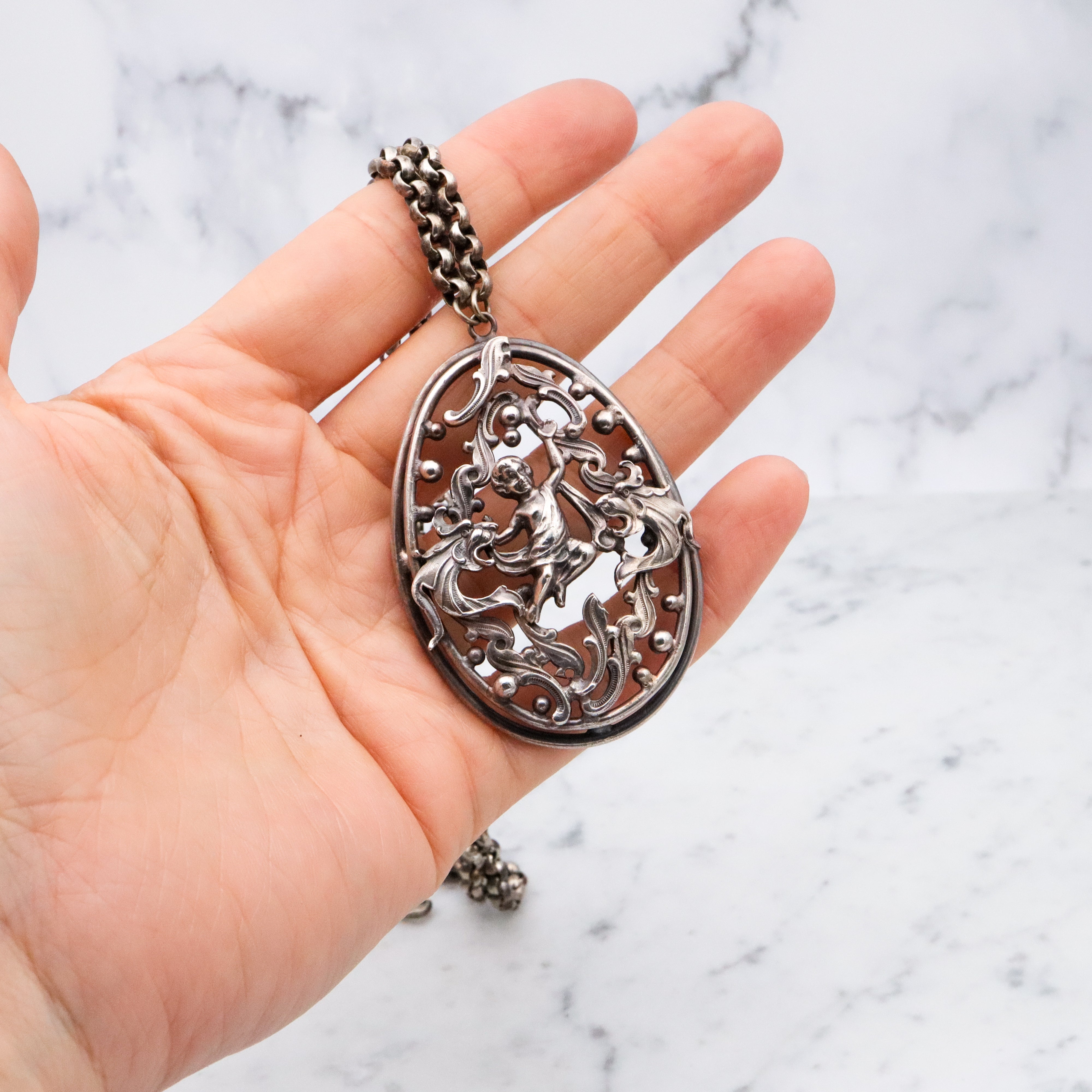 Antique Renaissance Revival silver plated putti & dragon cutout pendant necklace