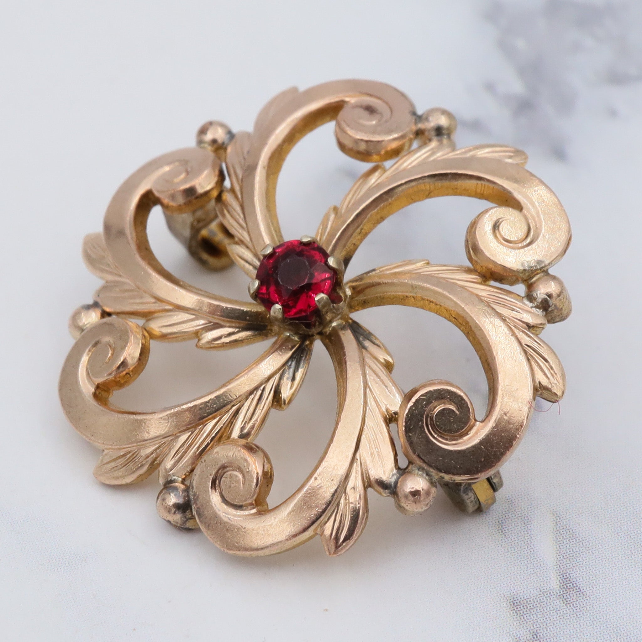 Antique Victorian pinchbeck swirl flower brooch with ruby crystal