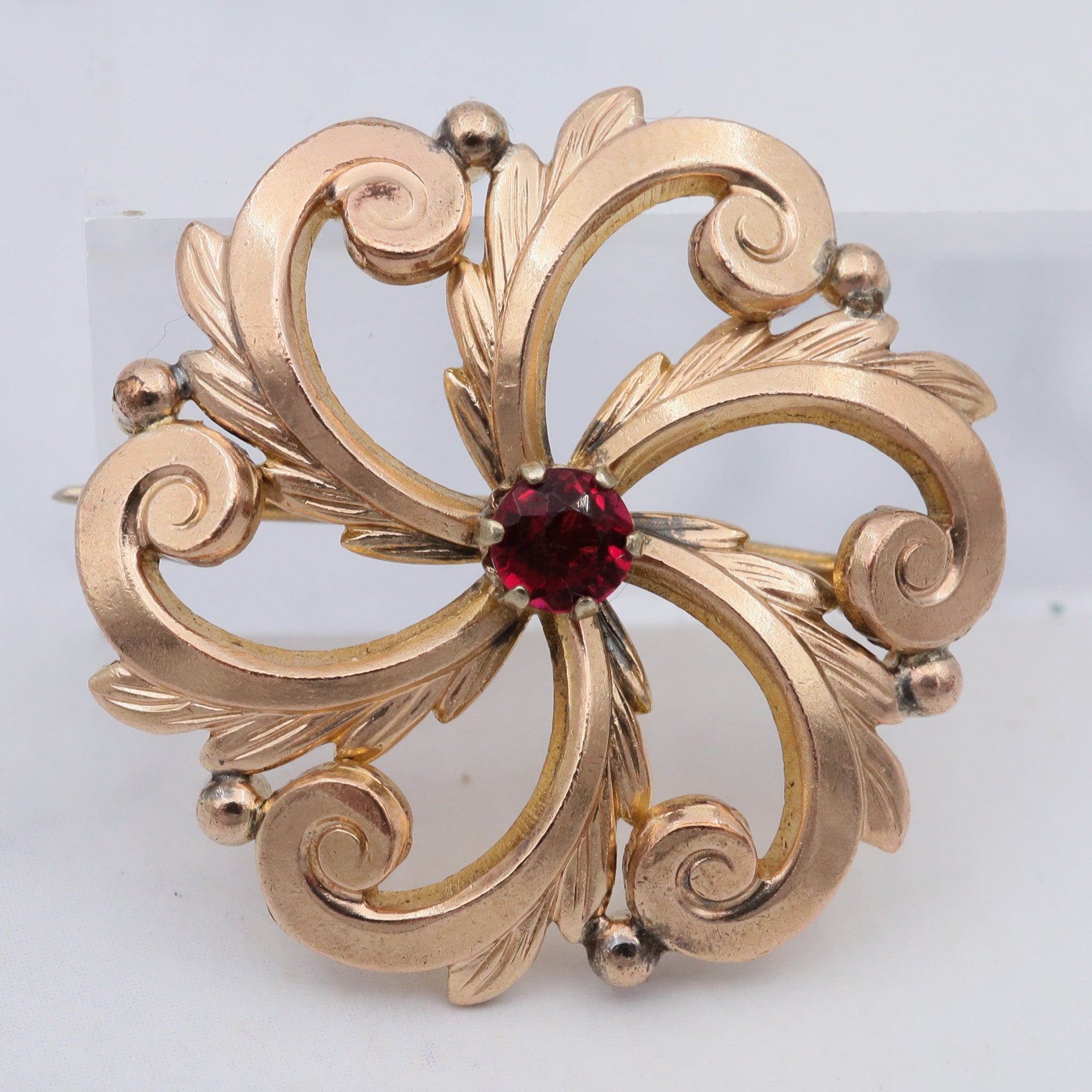 Antique Victorian pinchbeck swirl flower brooch with ruby crystal