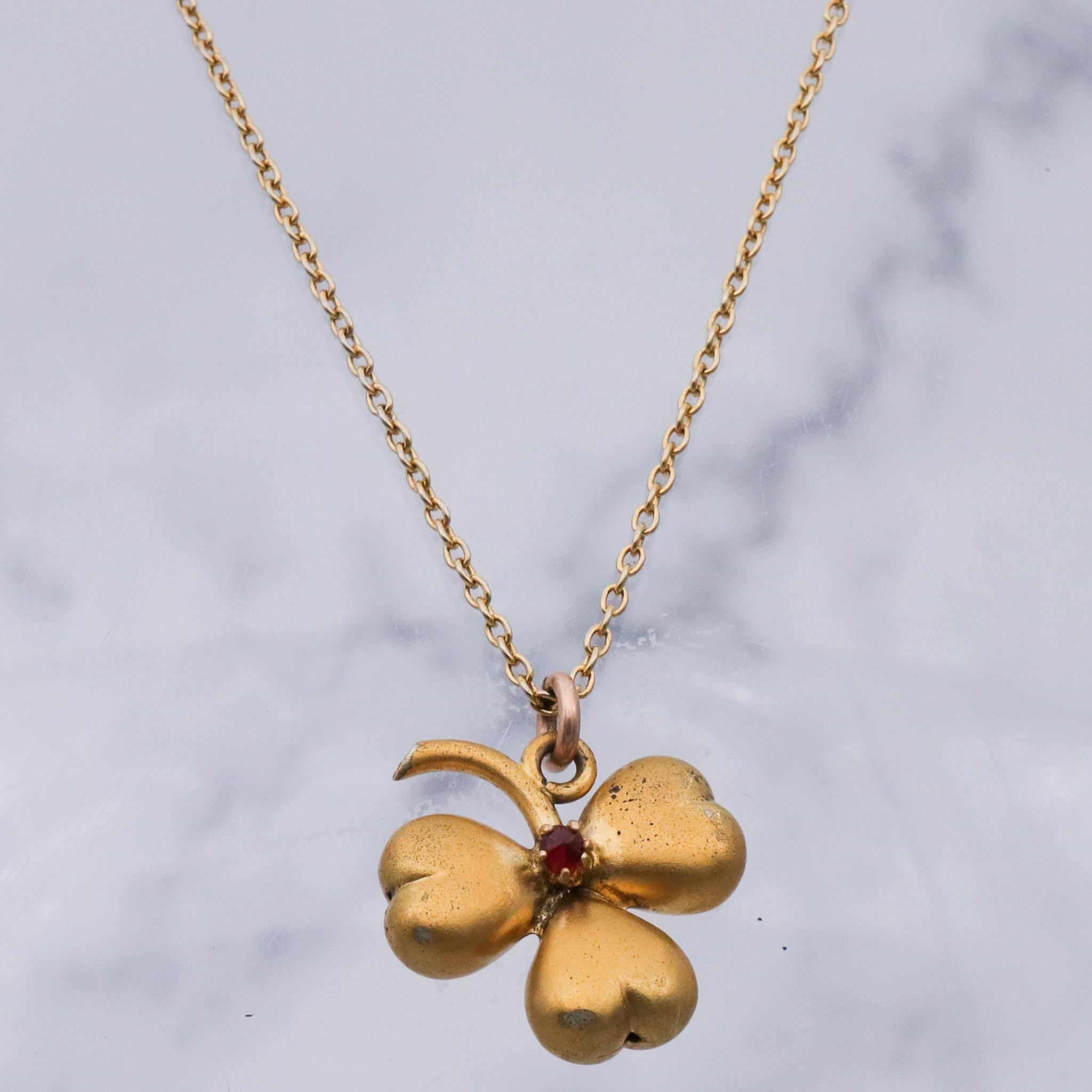 Antique Victorian gilt metal clover with faux garnet pendant